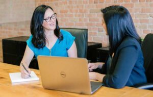 Two women talk in office.